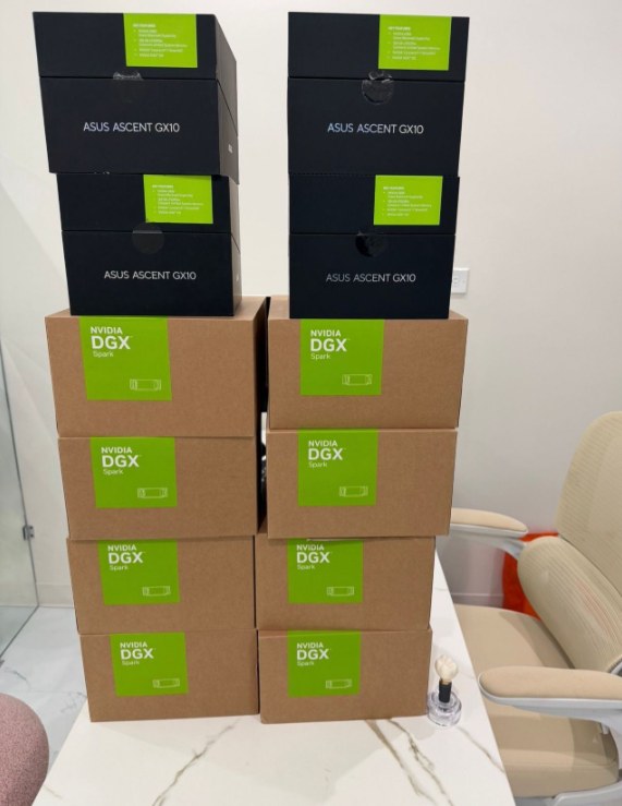 택배 상자 더미. 아래에 NVIDIA DGX Spark 상자 8개가 두 줄로 쌓여 있고, 그 위에 ASUS Ascent GX10 상자 4개가 놓여 있다.