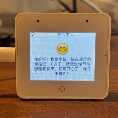 정사각형 기기 화면에 웃는 이모지와 중국어 문장이 떠 있다.