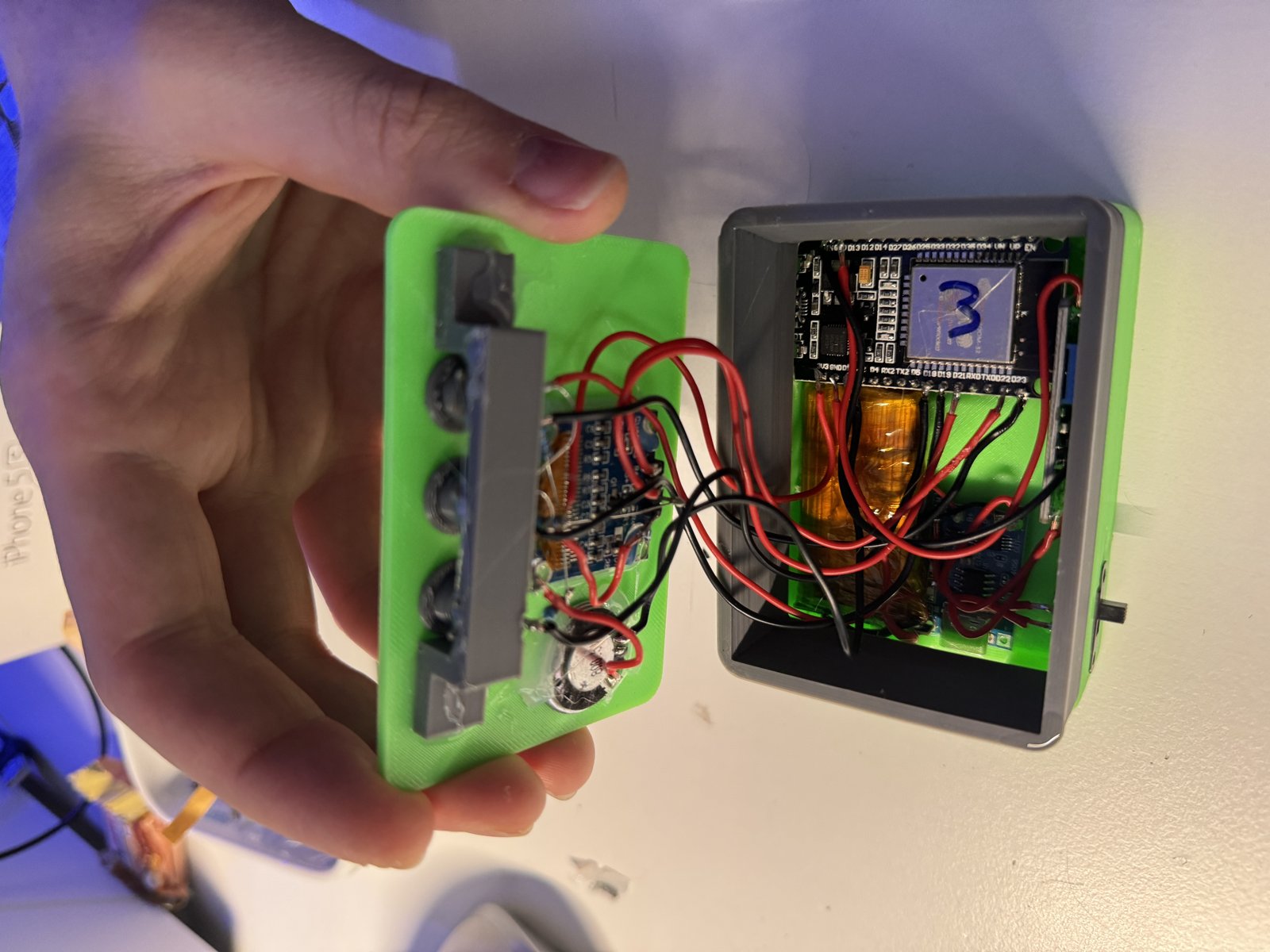 초록색 3D 프린팅 케이스를 열자 ESP32 보드, 배터리, 배선, 버튼이 보인다.