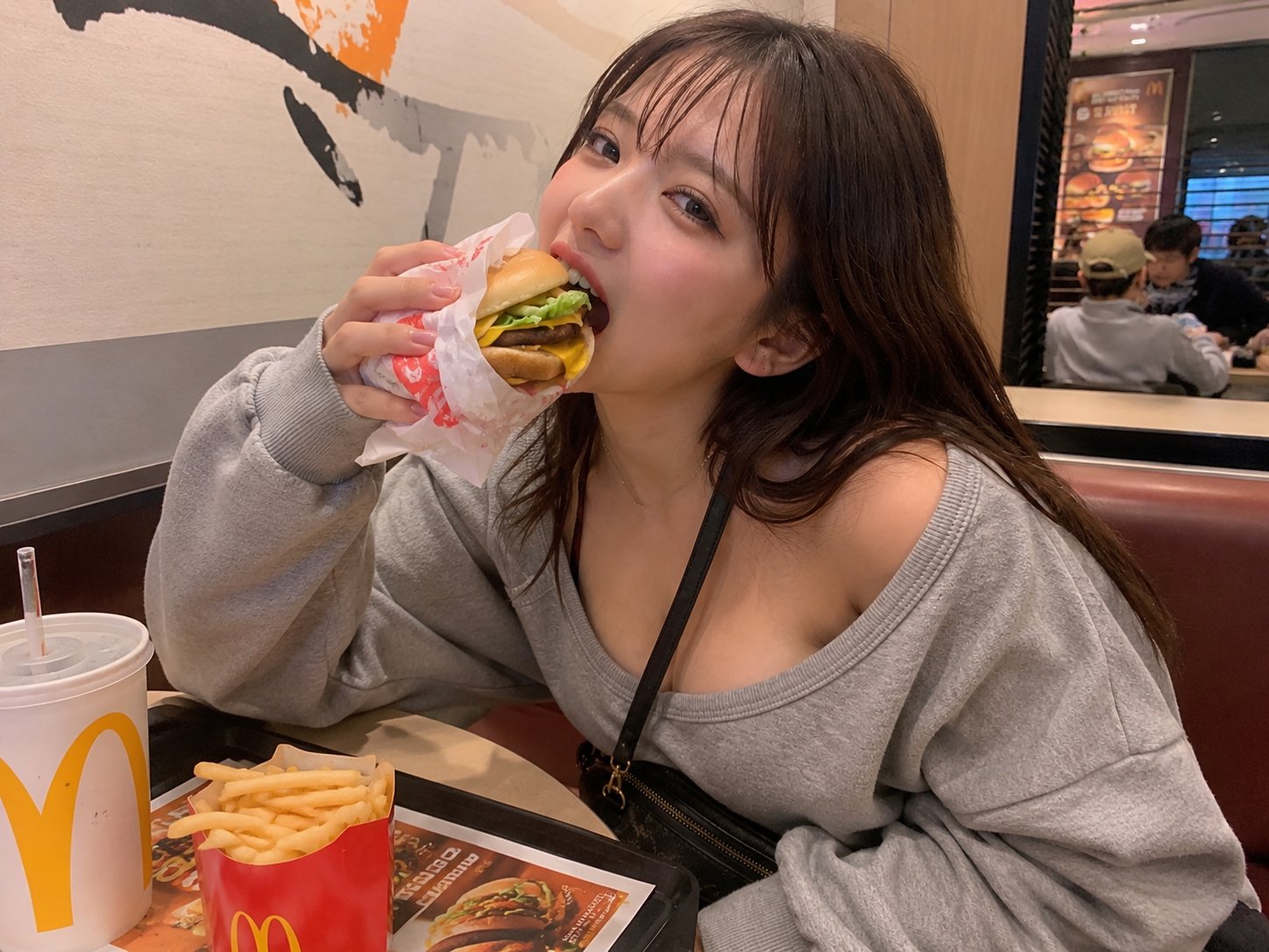 2장 헤더 — 맥도날드에서 햄버거를 한입 베어 무는 일상 셀카. &ldquo;내 폰에도 있을 법한 사진"의 전형